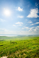 Fototapeta na wymiar Photo of beautiful landscape with grassy and land lake under sunny skies