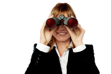 Corporate woman looking through binoculars