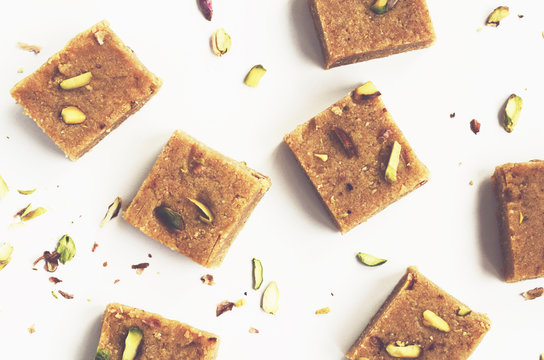 Homemade besan coconut burfi, traditional indian sweet made of coconut flakes, chickpea flour, cardamom and pistachio