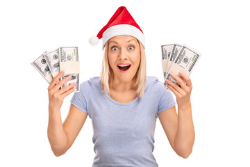 Overjoyed woman with Santa hat holding money