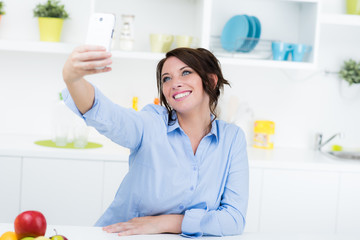 Moderne Hausfrau macht Selfie in der Küche