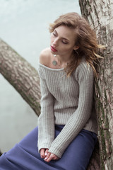 Young beautiful woman posing on a tree. 