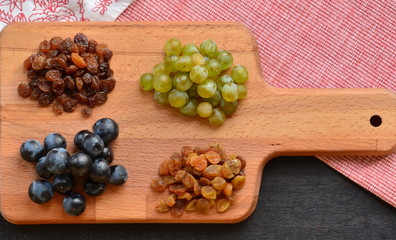 Various raisins and vine berries on chopping board