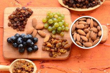 Various raisins, vine berries and almonds on chopping board