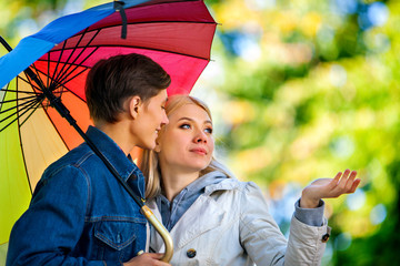 Loving couple on a date under umbrella.