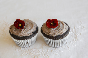 Homemade chocolate cupcakes with cookie and cream frosting and edible flower