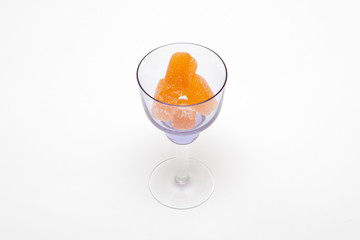 orange marmalade in black wineglass on white