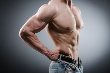 Fototapeta premium Muscular man posing in dark studio