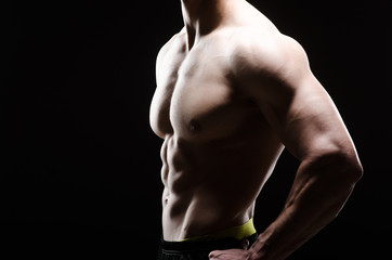 Fototapeta premium Muscular man posing in dark studio