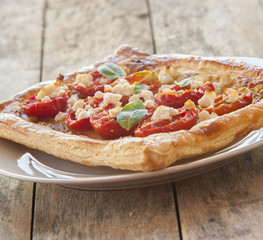 Tomato tart, puff pastry topped with mustard, cheese and cherry toamtoes.