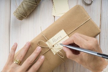 Mujer preparando regalos y etiquetas para la celebración de la navidad