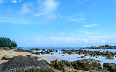 Fototapeta na wymiar Rock beach and blue sky with beautiful clouds in Phuket Thailand