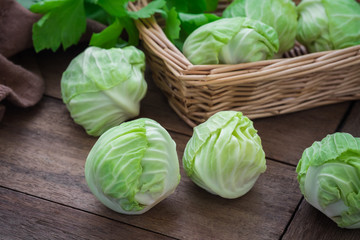 Cabbage on wooden table and basket