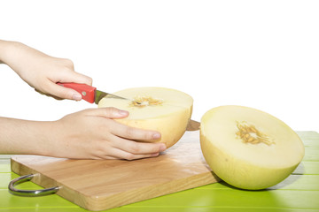 Cantaloupe is being cut on a cutting board.