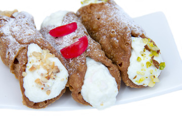 Cannoli with ricotta cheese on white background seen up close