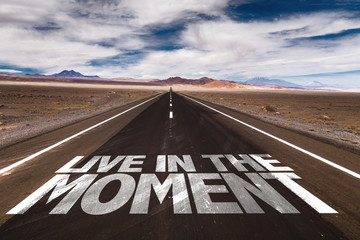 Live in the Moment written on desert road