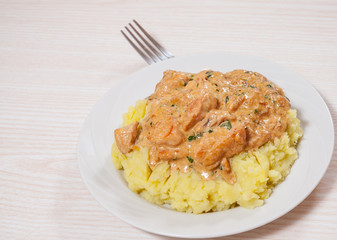 chicken breast in a creamy sauce with mashed potatoes