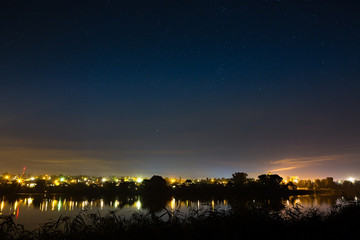 Stars in the night sky on a background city lighting. 