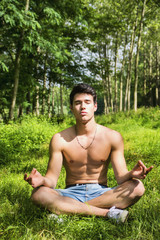 Naklejka na ściany i meble Young Man Meditating or Doing Outdoor Yoga Exercise