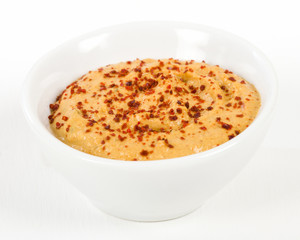 Roasted Pepper Hummus in a white bowl.
