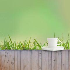 Coffee cup put on fence as green background texture