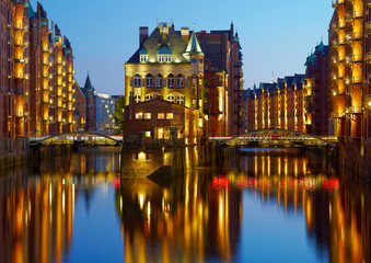 Old Speicherstadt in Hamburg illuminated at night. Sunset backgr