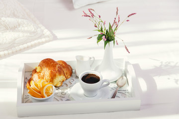 breakfast on wooden tray on the bed
