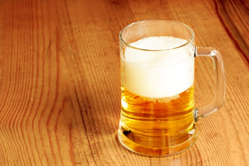 Mug of beer on wooden table