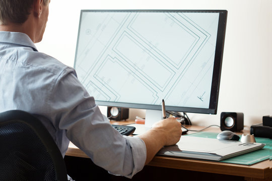 Graphic designer using digital tablet and computer in office or