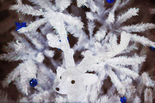 Decorated white Christmas tree at with decorative deer.