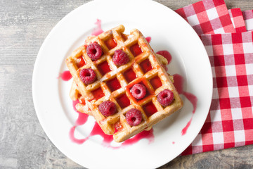Waffles with raspberries and strawberry syrup