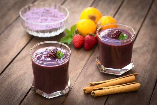 Ecuadorian traditional drink called Colada Morada, made of purple corn flour, fruits, cane sugar, cinnamon, allspice, cloves (Selective Focus, Focus on the blackberry on the left drink)