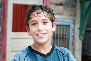 closeup of a happy smiling boy dripping wet from a sprinkler