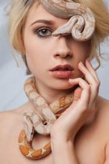 Naklejka premium Beautiful girl and the snake Boa constrictors, which wraps