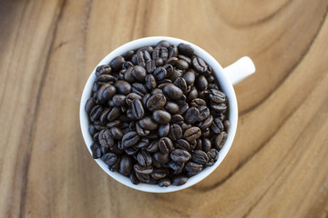 Roasted coffee beans in white cup
