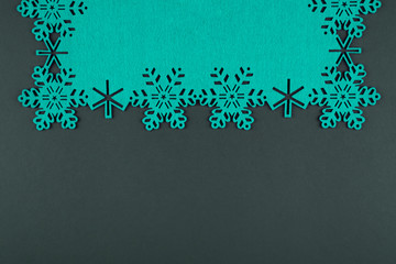 Unusual design christmas background with turquoise snowflakes and copy space on dark grey background