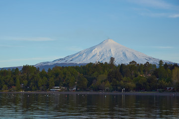 Snow capped cone of Villarrica Volcano (2,860m) rising above Lake Villarrica in the lake district of southern Chile