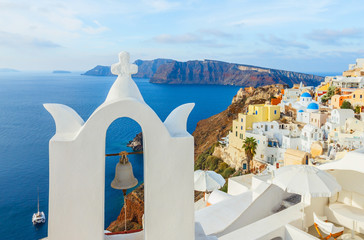 Cityscape of Oia on a sunny day with white top of church, Santorini, Greece
