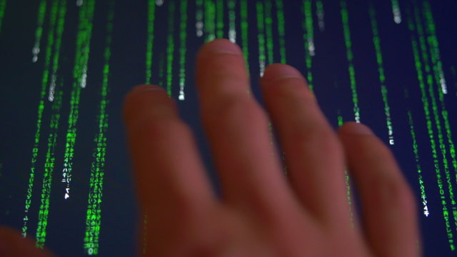The hand touch monitor computer with green matrix code. Close up view