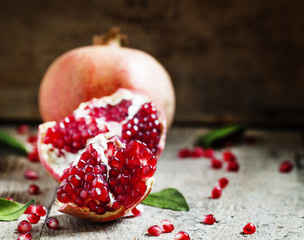 Ripe red pomegranate on an old wooden table, selective focus