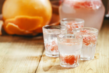 Soda with pink grapefruit in glasses on an old wooden table, sel