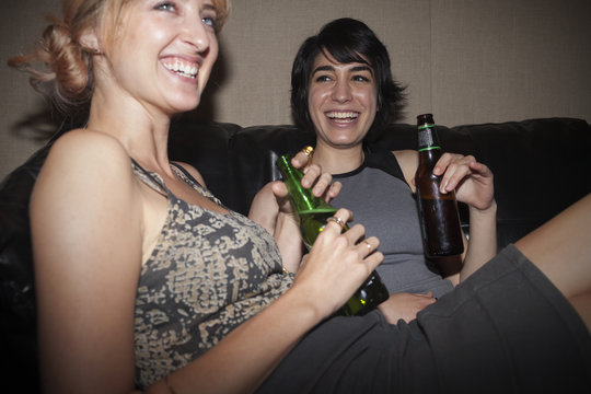 Young women enjoying a beer at a party