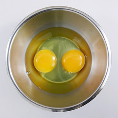 The fresh eggs in the stainless steel bowl.