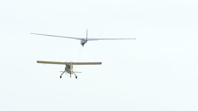 Plane pulls  glider on  cable in air, rear view 4K 3840x2160