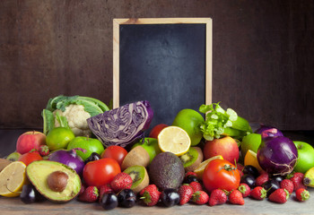 Fruits and vegetables around empty chalkboard