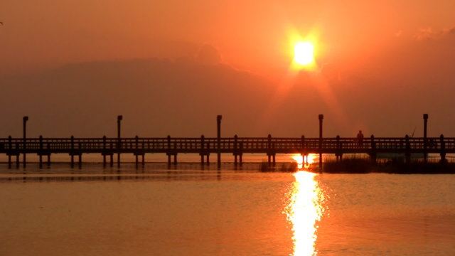 Fishing pier boat passing reflection sunset HD