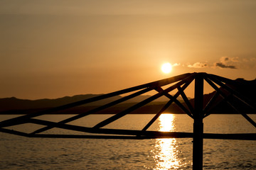 Fototapeta na wymiar Silhouette of a beach umbrella at sunset on the island of Rhodes