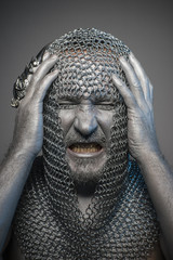 man in chain mail and leather painted silver, medieval warrior