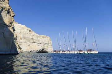 Sailing yachts anchored in a gulf in Milos island, Cyclades, Greece