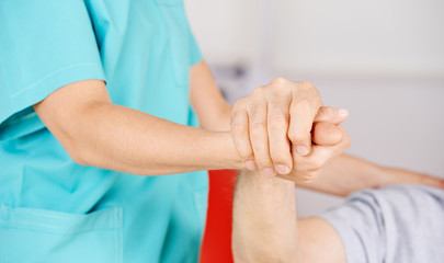 Krankenschwester hält Hand eines Senioren